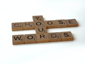 Scrabble letter that spell out "Choose Your Words" in context of mindful language when speaking to a friend with a mental health condition.